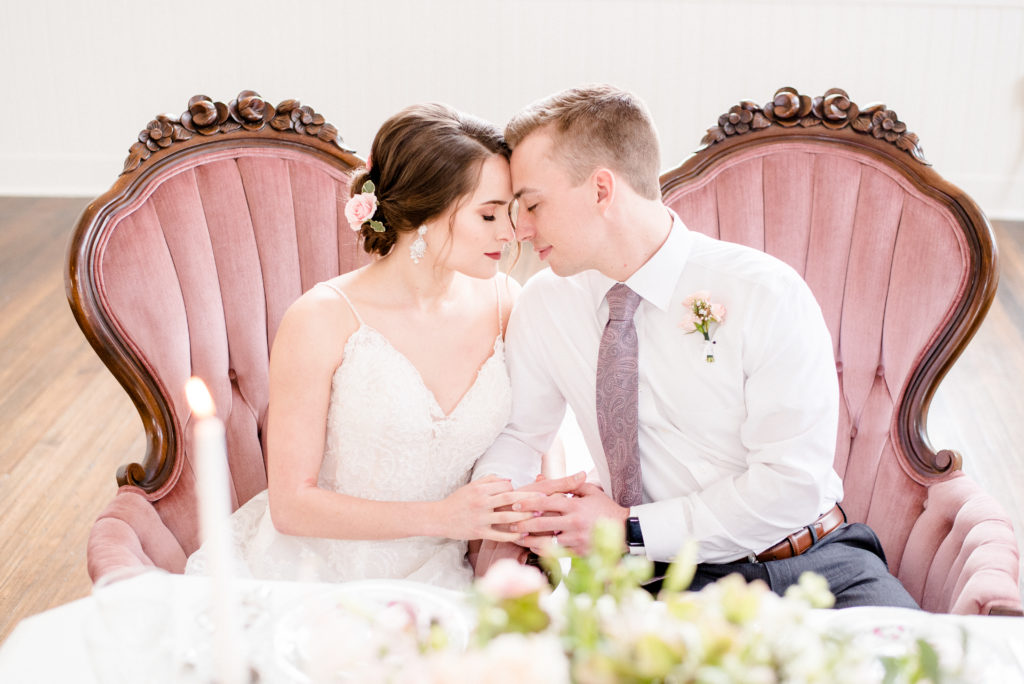 pretty in pink styled shoot bride and groom at sweetheart table