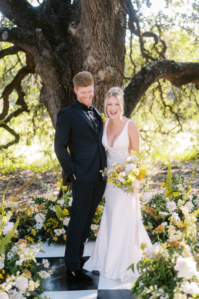 bride and groom laughing at yellow wedding ceremony