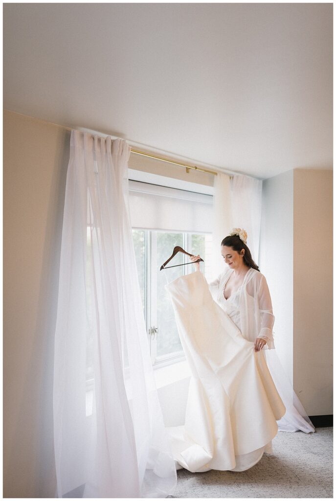 bride admiring wedding dress