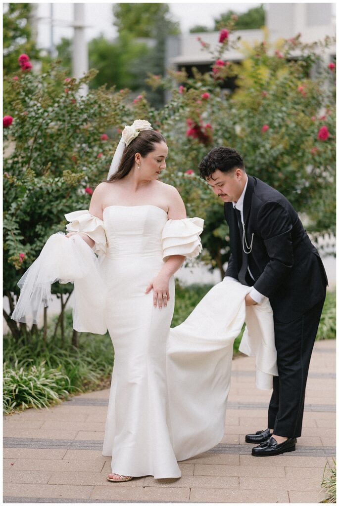 groom fixing bride's dress